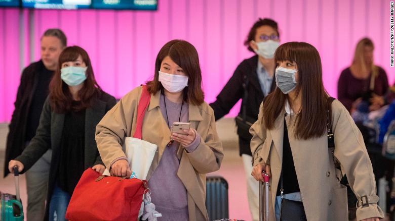 Passengers wear protective masks to protect against the spread of the Coronavirus as they arrive at the Los Angeles International Airport, California, on January 22, 2020. - A new virus that has killed nine people, infected hundreds and has already reached the US could mutate and spread, China warned on January 22, as authorities urged people to steer clear of Wuhan, the city at the heart of the outbreak. (Photo by Mark RALSTON / AFP) (Photo by MARK RALSTON/AFP via Getty Images)